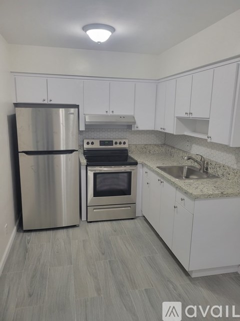 A kitchen with a stainless steel refrigerator, oven, and cabinets.
