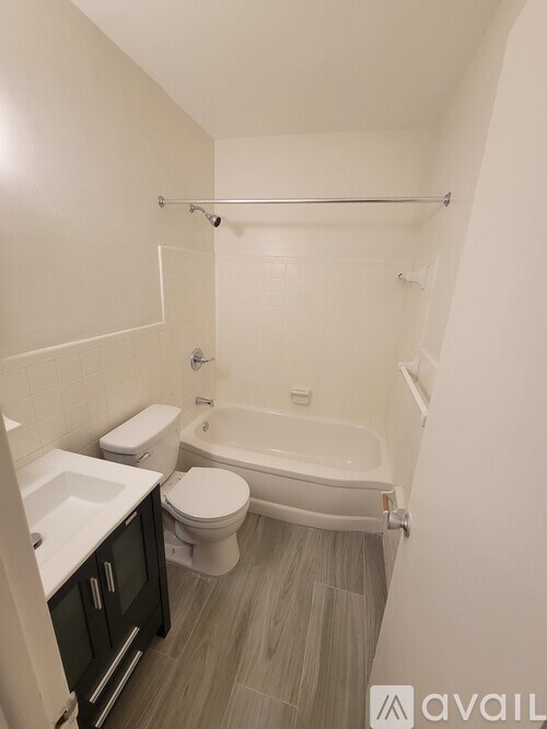 A bathroom with a toilet, sink, and bathtub.