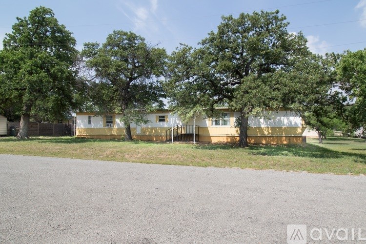 A row of houses with trees in front.