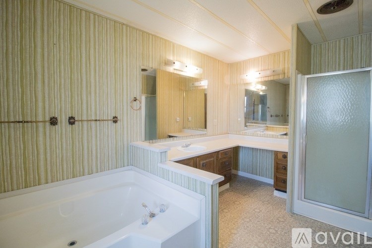 A bathroom with a bathtub, sink, and mirror.
