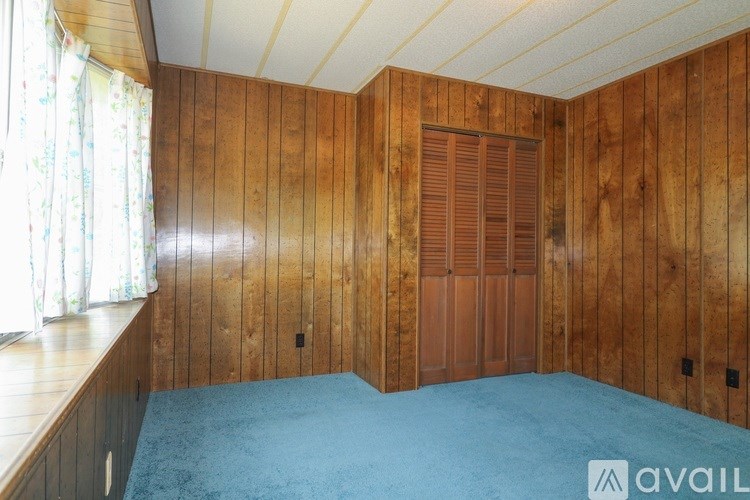 A room with wooden walls and a blue carpet.