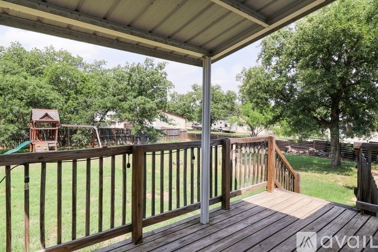 A wooden deck with a metal railing and a covered area.