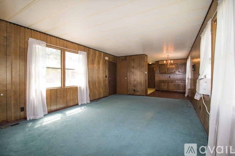A room with wooden walls and a blue carpet.