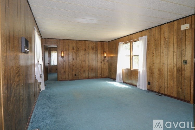 A room with wooden walls and a carpeted floor.