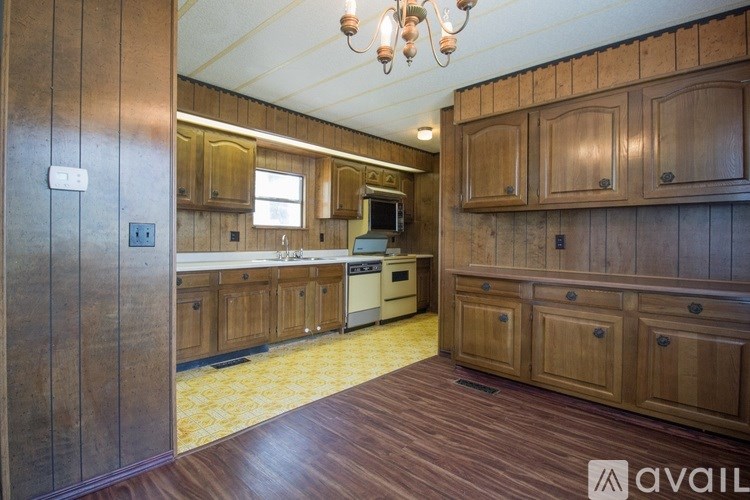 A kitchen with wooden cabinets and a stove top oven.