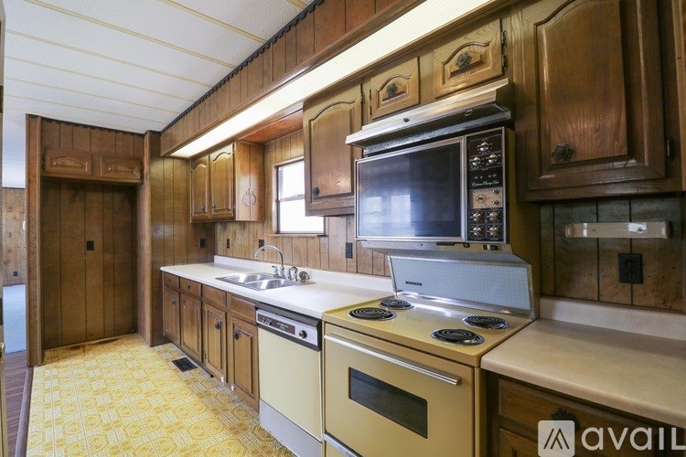 A kitchen with wooden cabinets and a yellow floor.