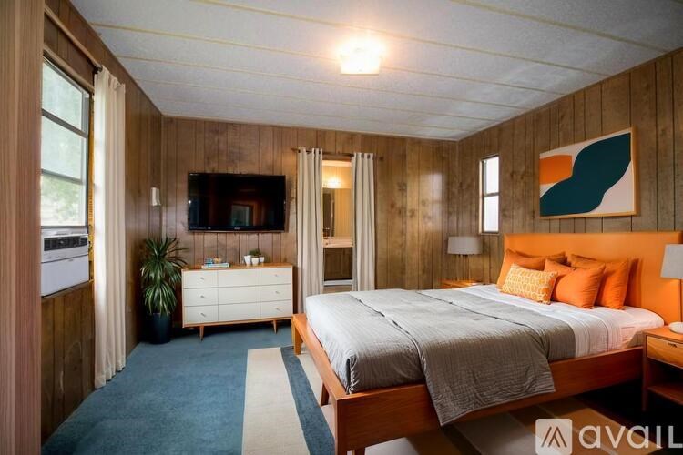 A bedroom with a bed, nightstand, and television.