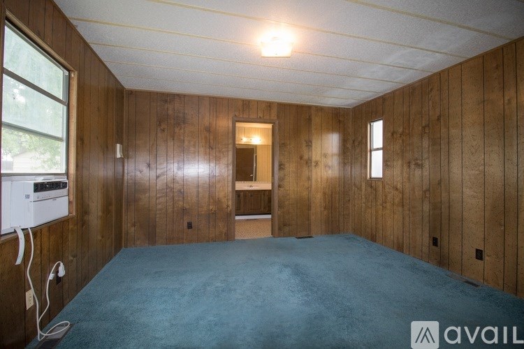 A room with wooden walls and a blue carpet.