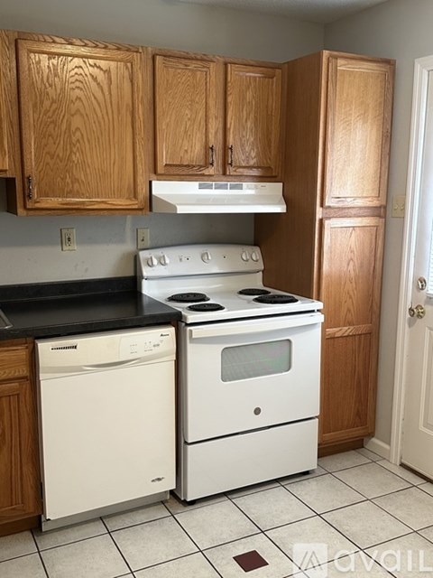 A kitchen with wooden cabinets and white appliances.