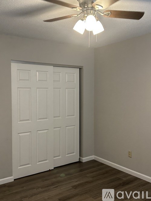 A white door in a room with a ceiling fan.