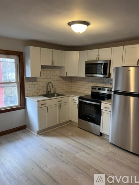 A kitchen with white cabinets and stainless steel appliances.