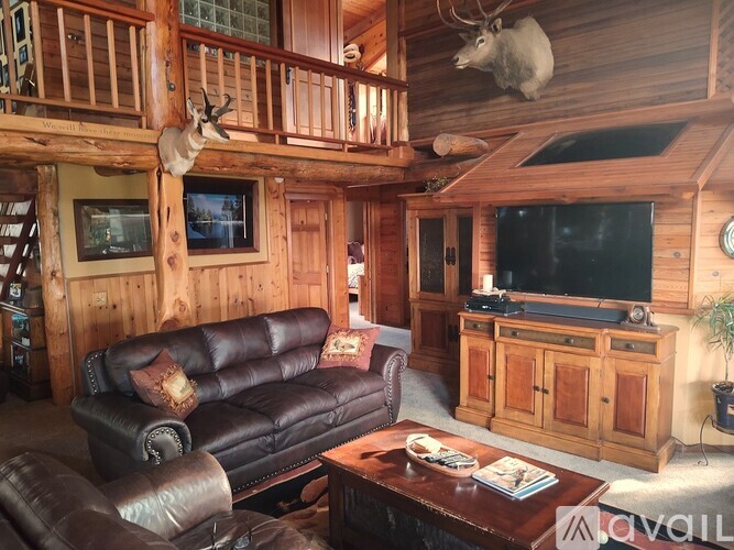 A living room with a couch, a coffee table, and a TV.