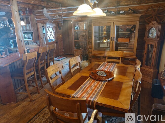 A wooden dining room with a table set for six.
