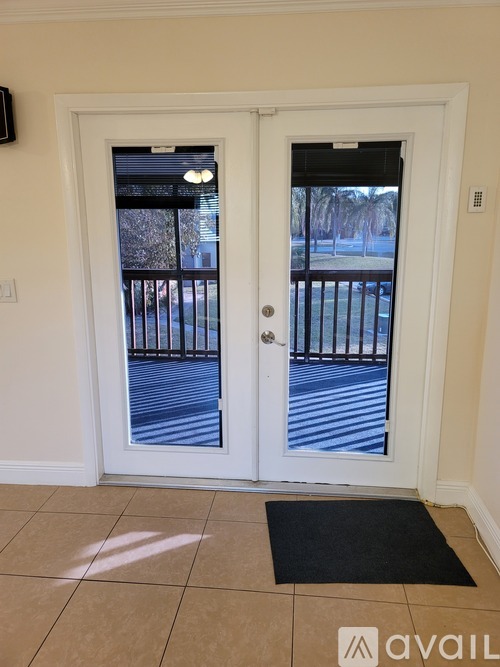A white door with a black mat in front of it.