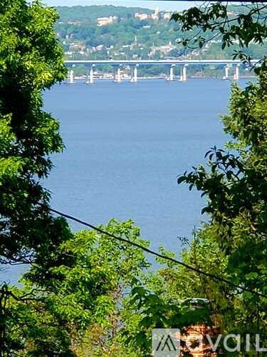 A bridge over a body of water with trees in the foreground.