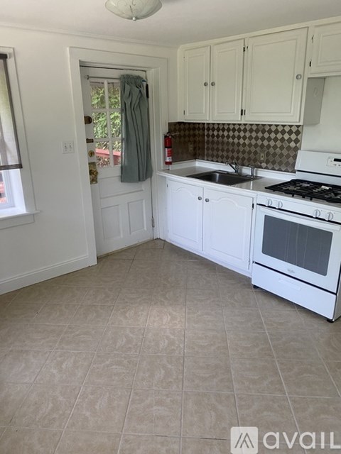 A kitchen with white appliances and cabinets.