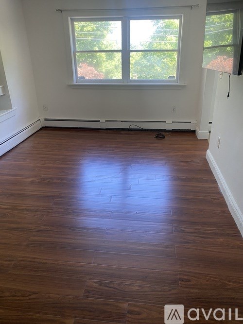A room with wooden flooring and a window.