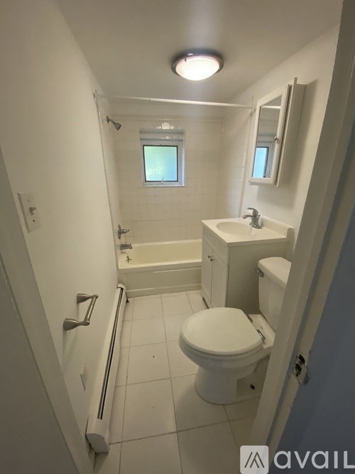 A white bathroom with a toilet, sink, and bathtub.