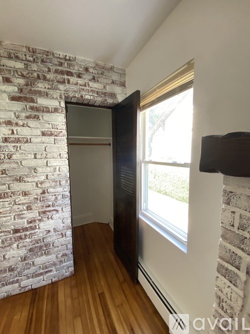 A room with a white brick wall and a wooden floor.