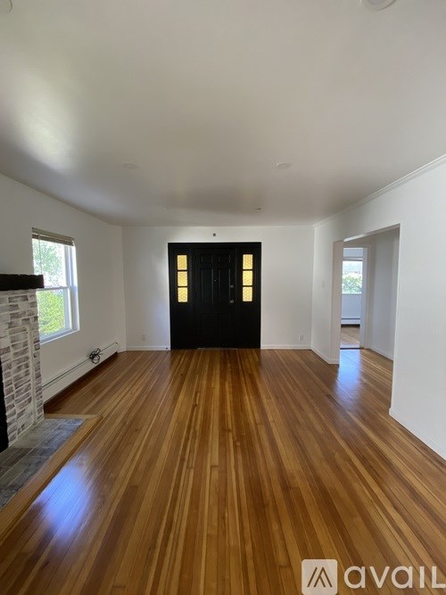 A room with wooden floors and a black door.