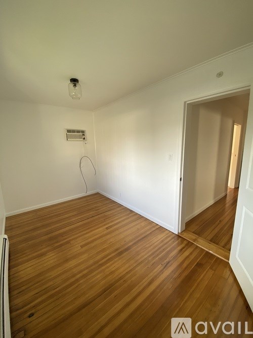 A room with wooden flooring and a white door.