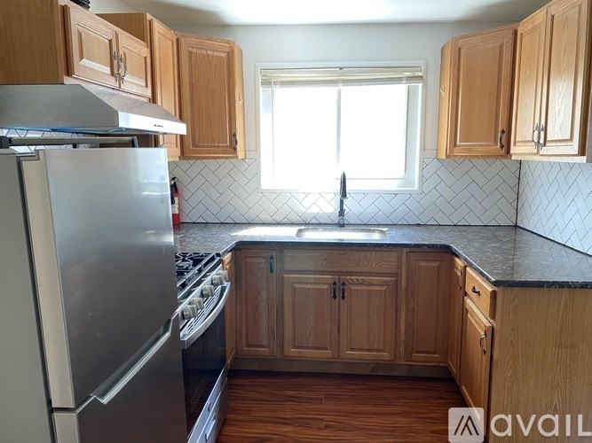 A kitchen with wooden cabinets and a stainless steel refrigerator.