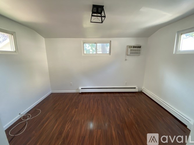 A room with wooden flooring and white walls.