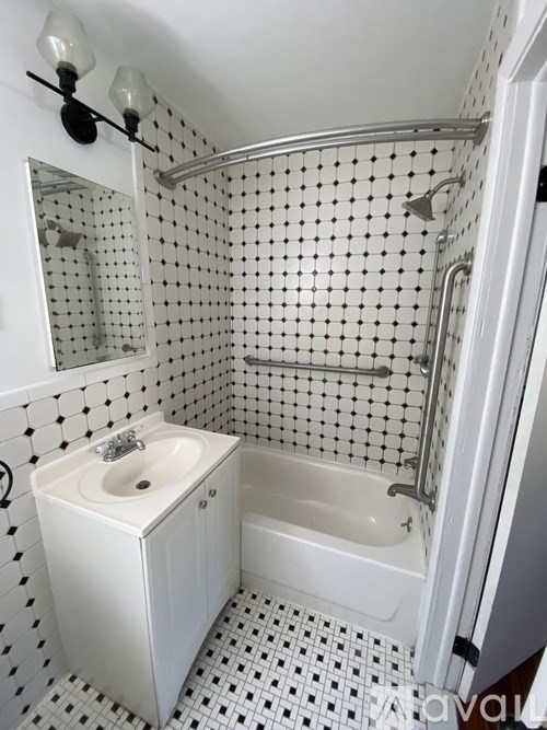 A white bathroom with a black and white checkered floor.