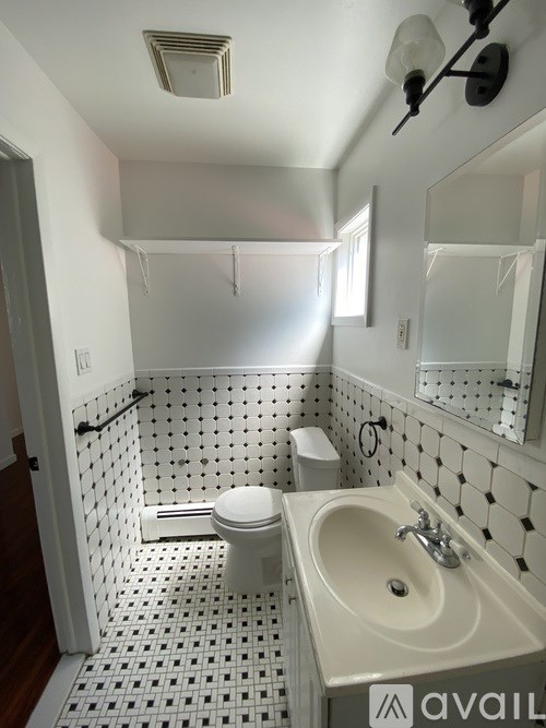 A bathroom with a toilet, sink, and shower.