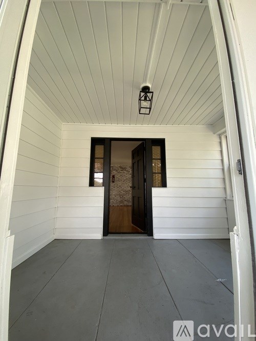 A hallway with a wooden door and a lantern hanging from the ceiling.