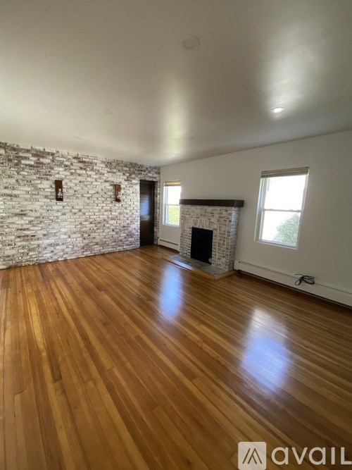 A room with wooden floors and a stone wall.