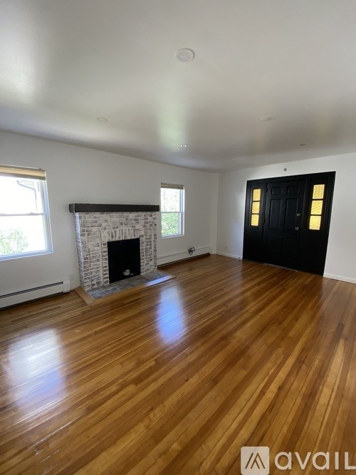 A room with wooden floors and a fireplace.