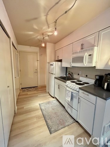 A kitchen with white appliances and cabinets.