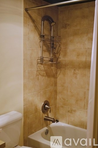 A tiled bathroom with a shower and a toilet.