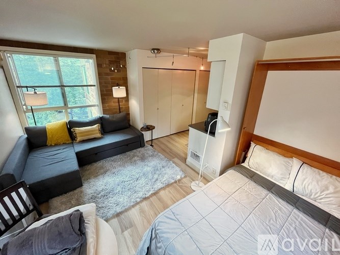 A bedroom with a bed, a couch, and a chair.