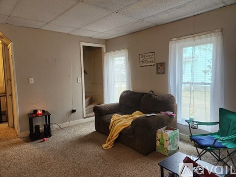 A living room with a brown couch and a green chair.