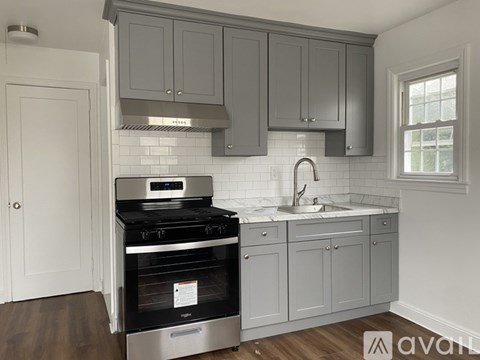 A kitchen with a stove top oven and a sink.