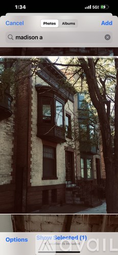 A building with a balcony and a tree in front of it.