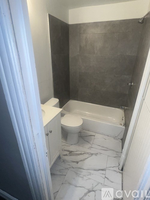 A bathroom with a toilet, sink, and bathtub.