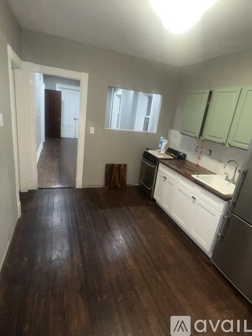 A kitchen with white appliances and green cabinets.
