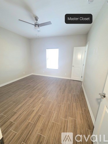 A room with wooden flooring and a ceiling fan is labeled as a master closet.