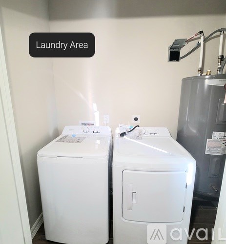Two white front loading washing machines in a laundry area.