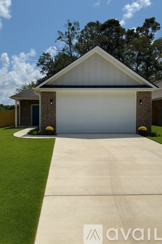 A house with a white garage door and a brown brick wall.