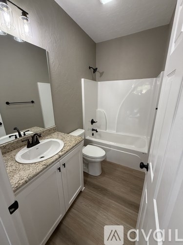 A bathroom with a sink, toilet, and bathtub.