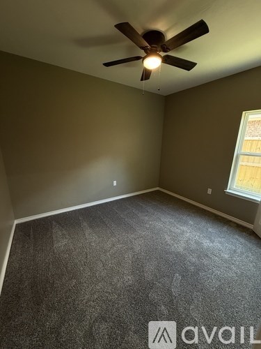 A room with a ceiling fan and carpeted floor.