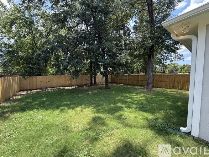 A backyard with a fence and trees.
