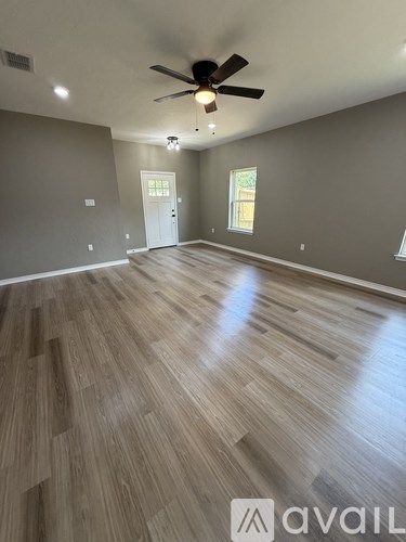 A room with wooden flooring and a ceiling fan.
