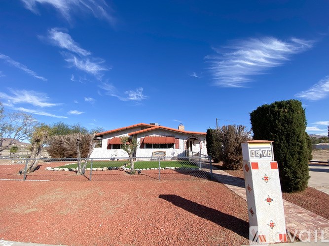 A sign in front of a house with a red roof.