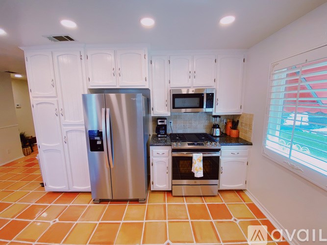 A kitchen with a refrigerator, microwave, oven, and stove.