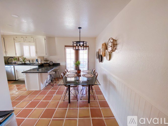 A kitchen with a table and chairs in the middle of the room.